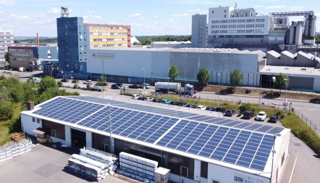 Ein Blick über das Werk der profine in Pirmasens mit einer Photovoltaikanlage im Vordergrund.
